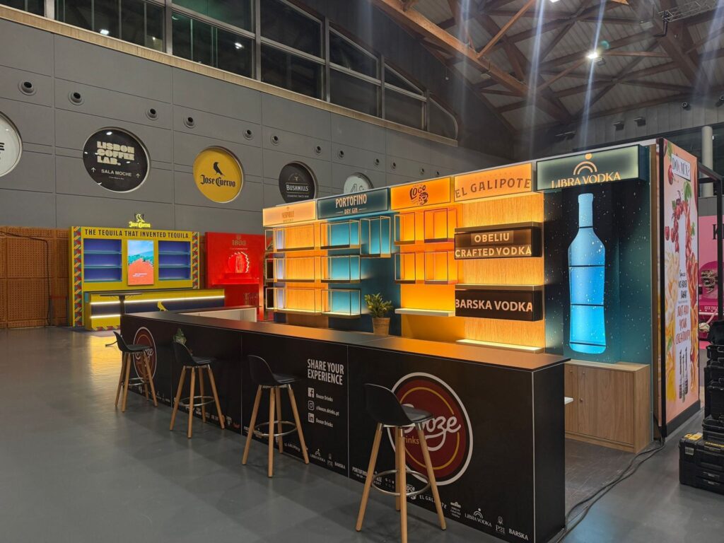 Stand de bar Booze Drinks com balcão em L e estantes retroiluminadas