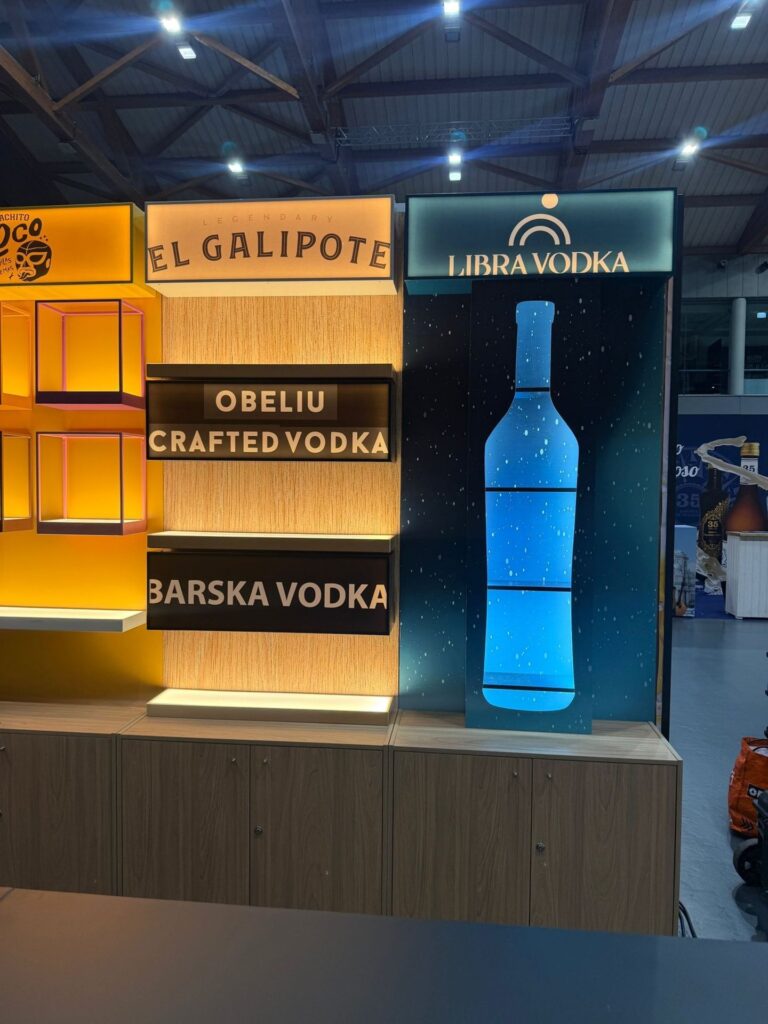 Estantes retroiluminadas e expositor-garrafa luminoso no stand Booze Drinks
