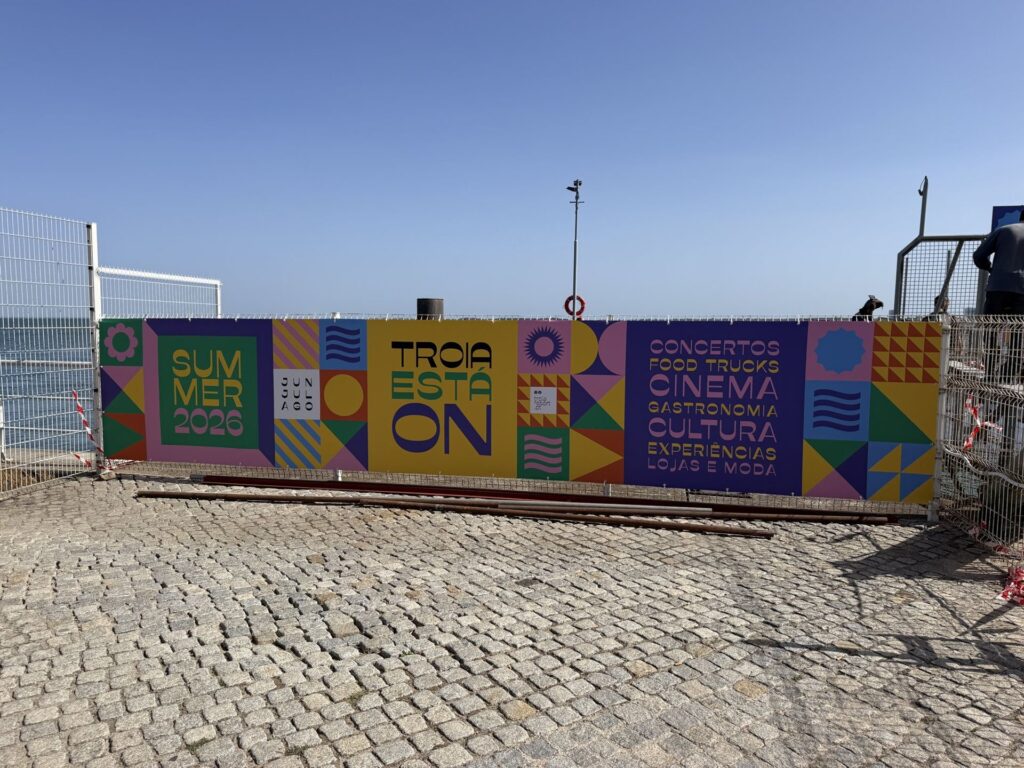 Painel Troia Está On na vedação junto à praia